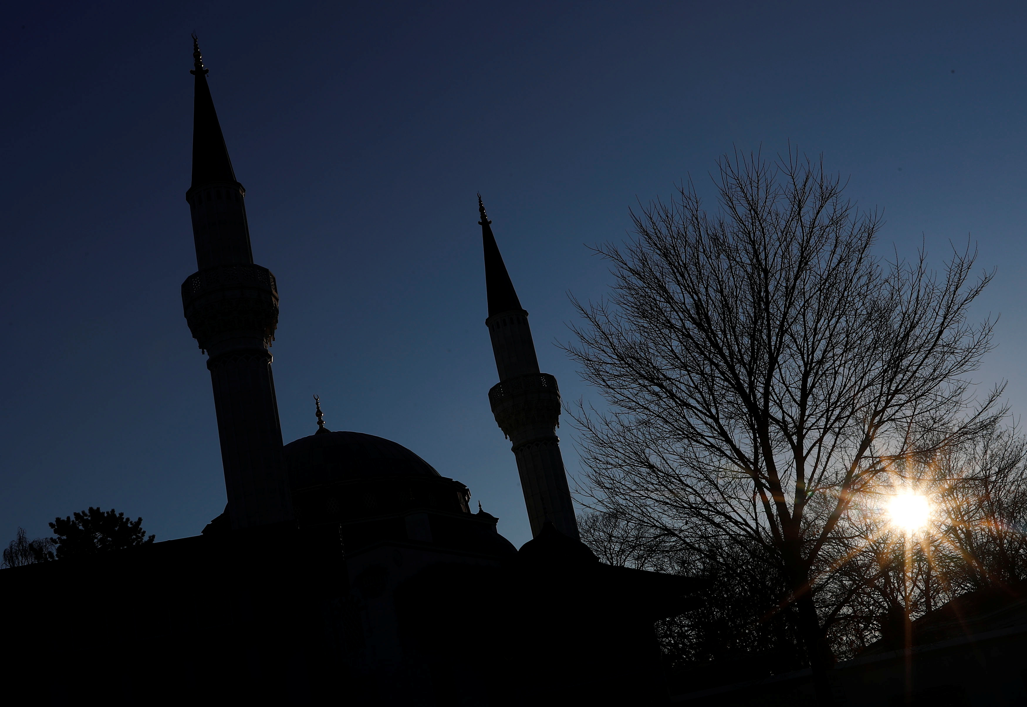 The sun is pictured beside the Sehitlik Mosque in Berlin