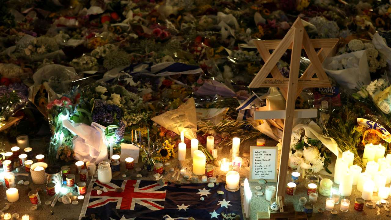 FILE PHOTO: An Australian flag sits amongst floral tributes honouring the victims of a shooting at Jewish holiday celebration on Sunday at Bondi Beach, in Sydney