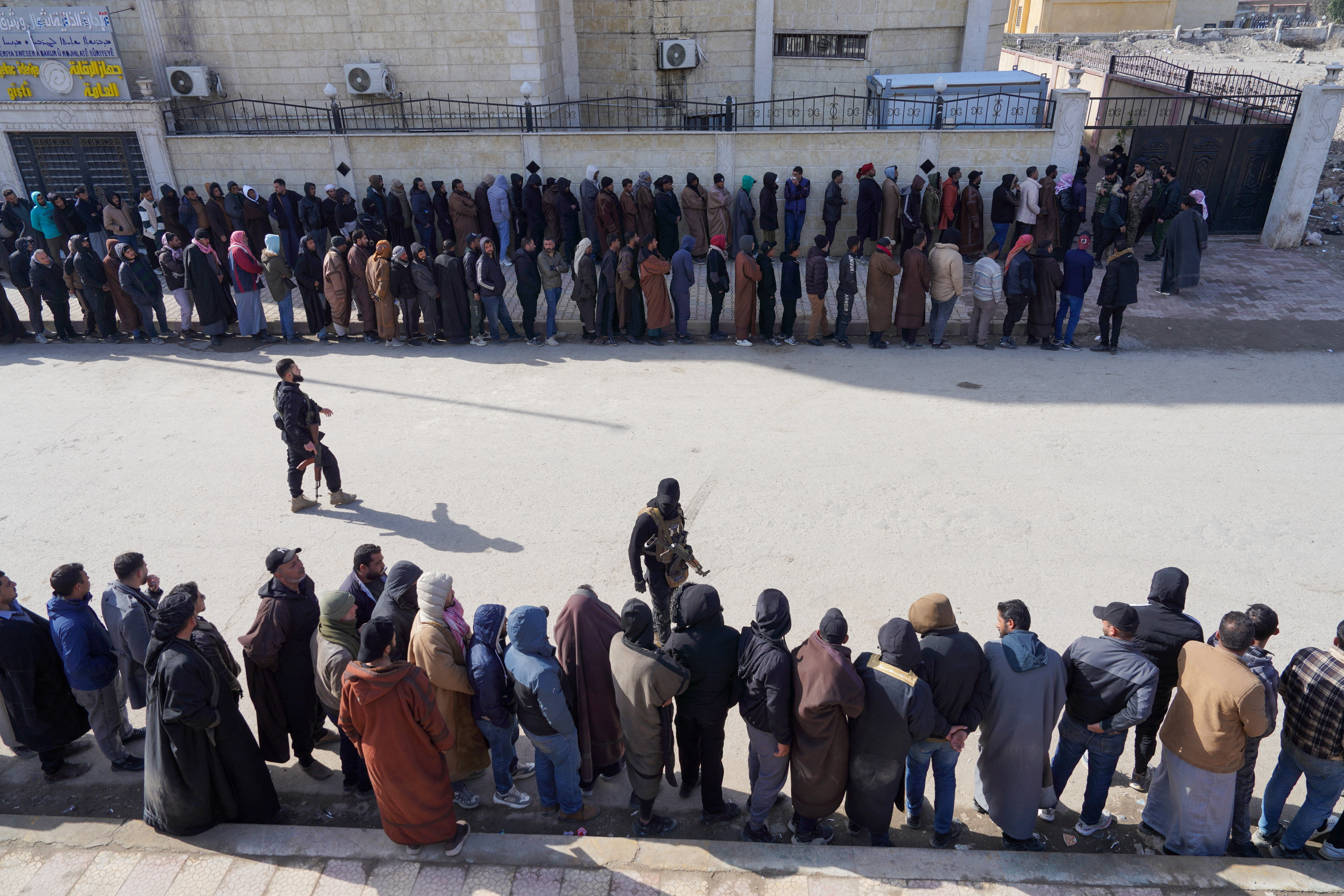 Members of the Kurdish-led Syrian Democratic Forces (SDF) queue to settle their status with Syrian government in Raqqa