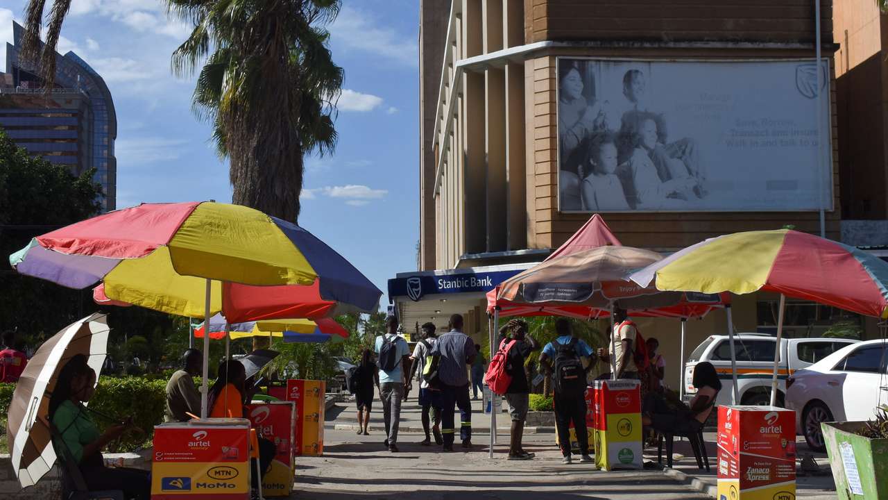 A line of mobile money agents sits at Lusaka's central business district