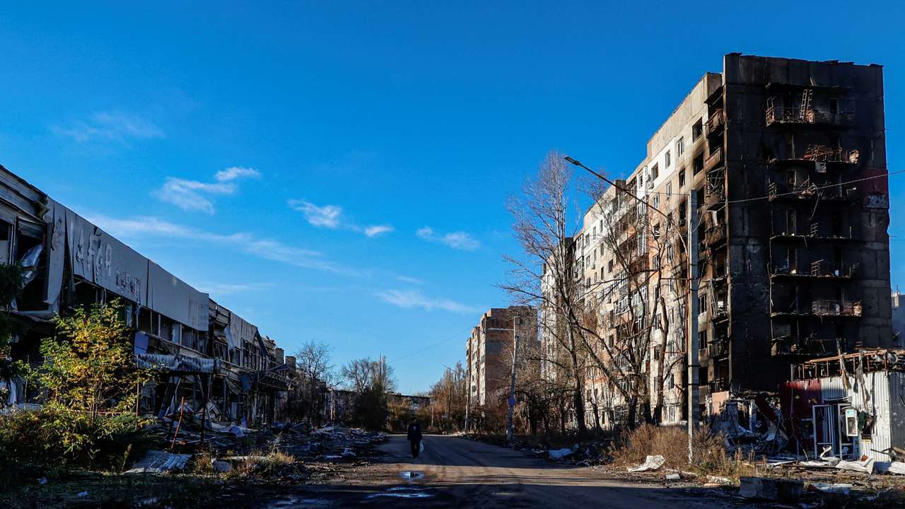 FILE PHOTO: Local resident walks next to residential buildings heavily damaged by permanent Russian military strikes in the front line town of Avdiivka