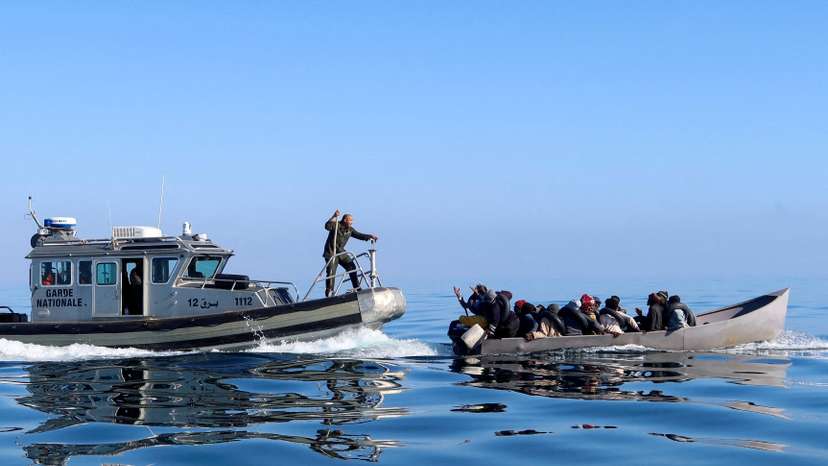FILE PHOTO: Tunisian coast guards try to stop migrants at sea, off Sfax