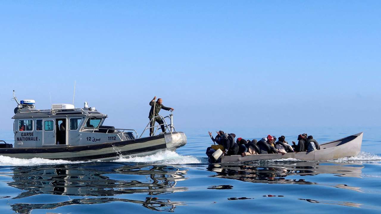 FILE PHOTO: Tunisian coast guards try to stop migrants at sea, off Sfax