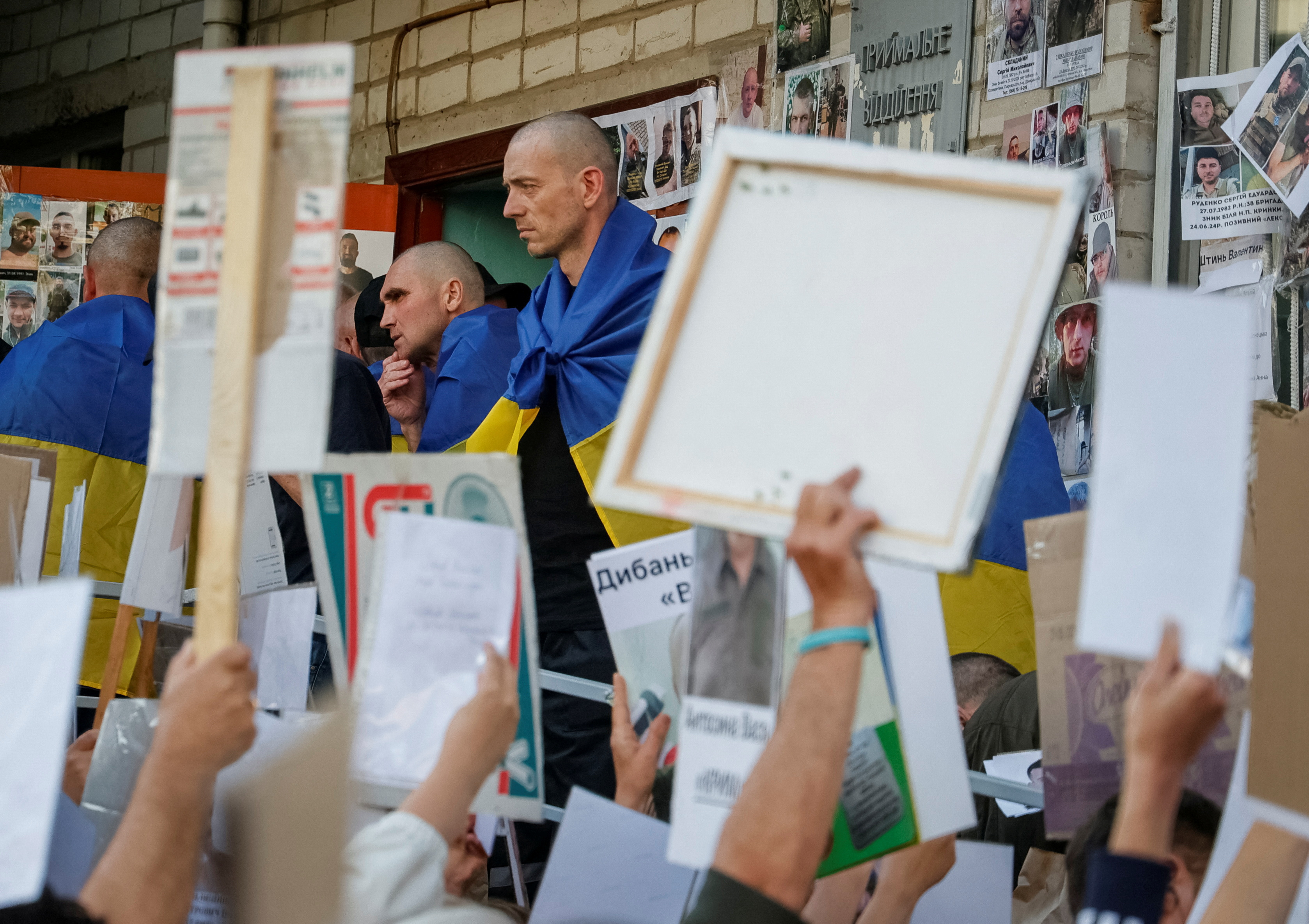 Ukrainian prisoners of war speak with relatives of another prisoners who are still in captivity, after a swap in an undisclosed location in Ukraine