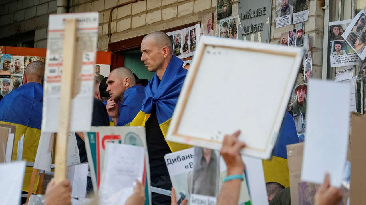 Ukrainian prisoners of war speak with relatives of another prisoners who are still in captivity, after a swap in an undisclosed location in Ukraine