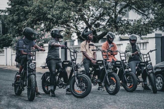 Some delivery riders who work with Valerie pose with the electric bikes.