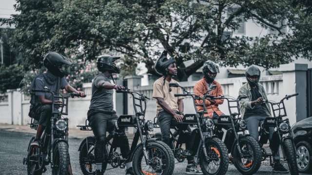 Some delivery riders who work with Valerie pose with the electric bikes.