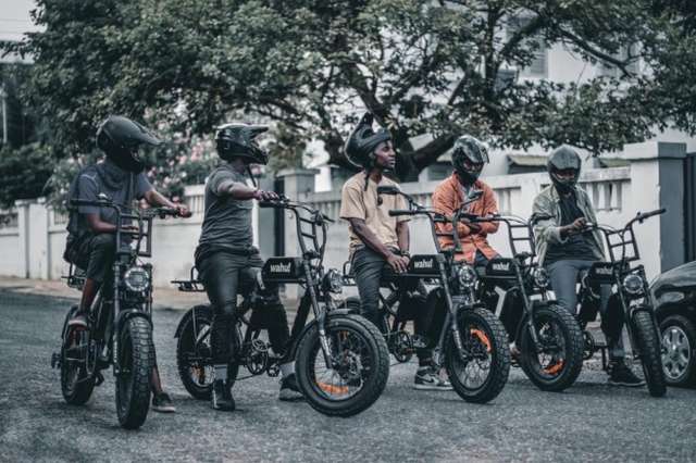 Some delivery riders who work with Valerie pose with the electric bikes.