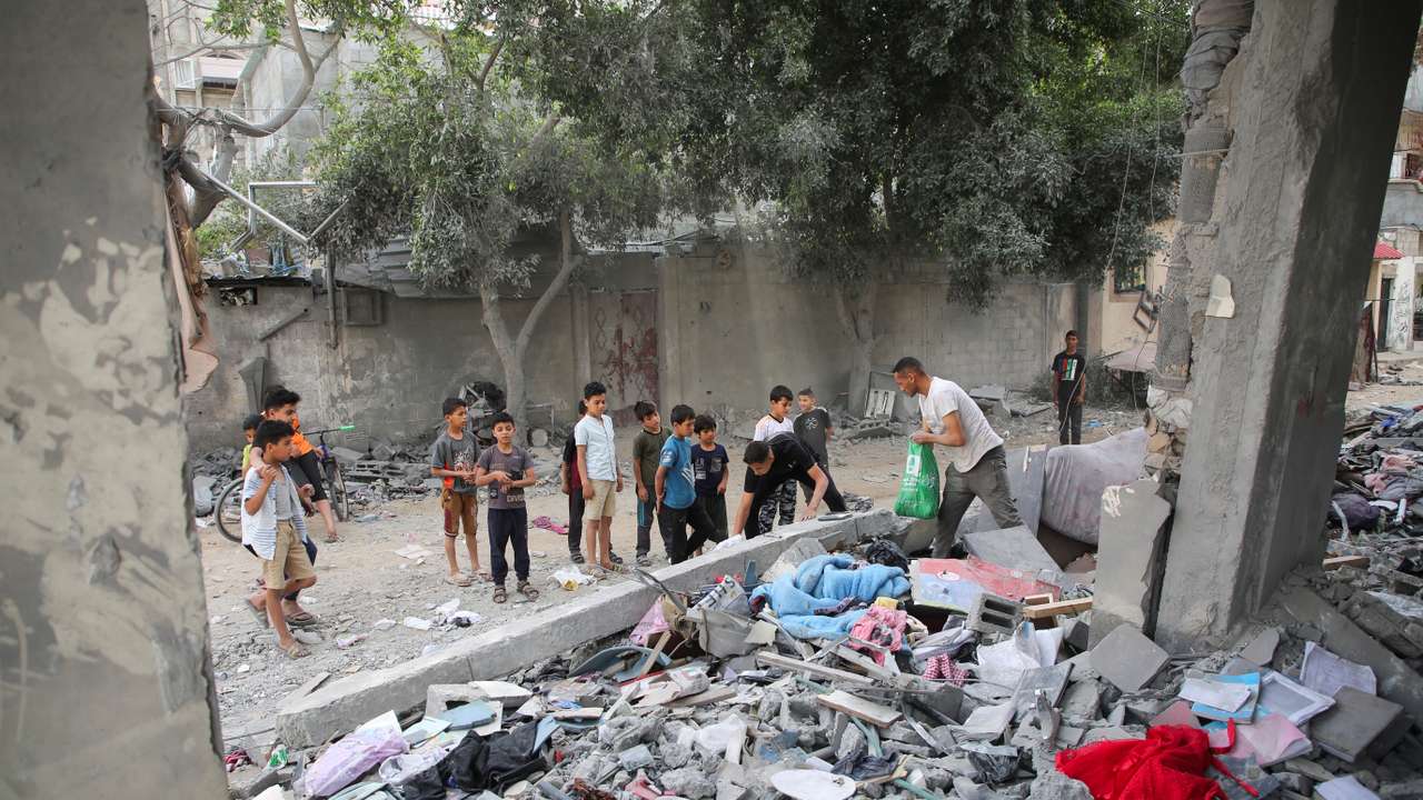 Palestinians inspect the site of an Israeli strike on a house in Rafah