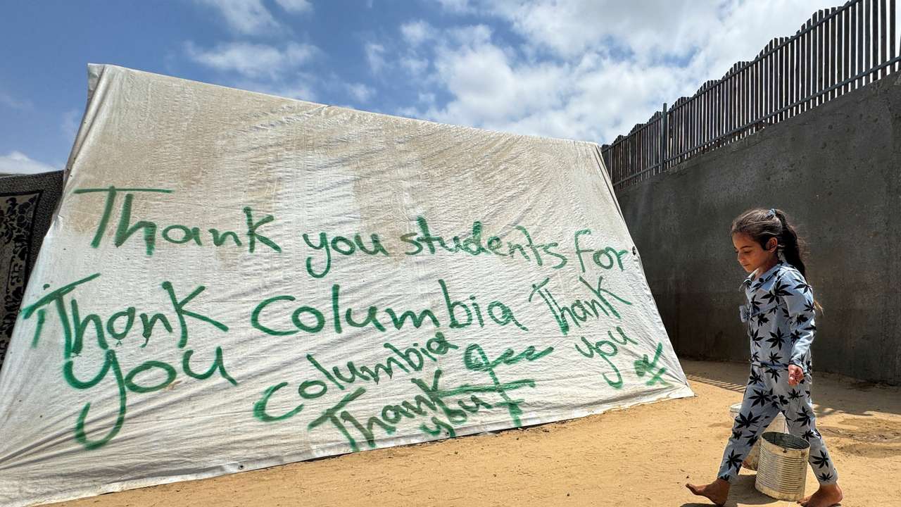 FILE PHOTO: A girl walks next to a tent, in Rafah