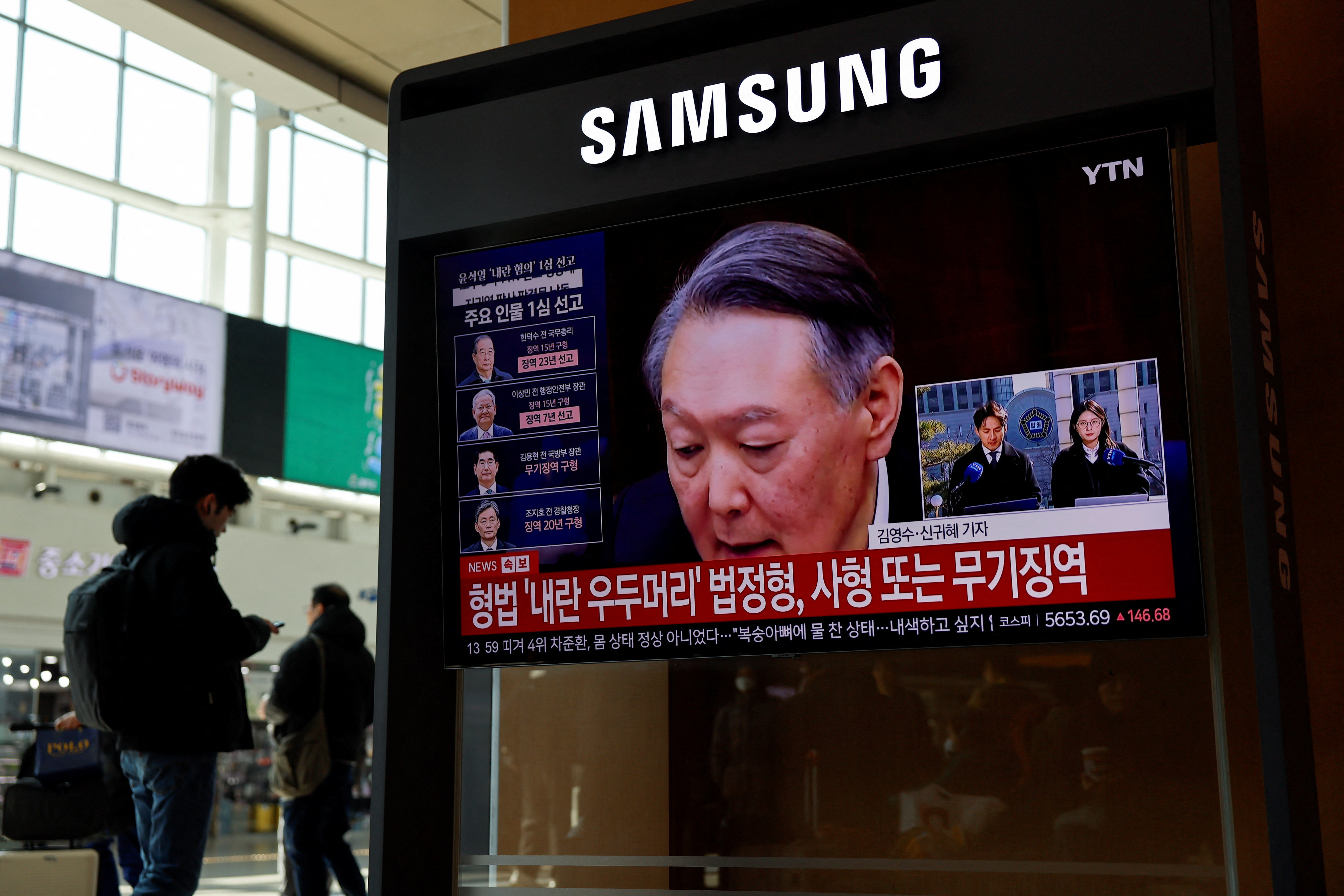 People watch a news report on the sentencing trial of South Korean former president Yoon Suk Yeol's insurrection case in Seoul