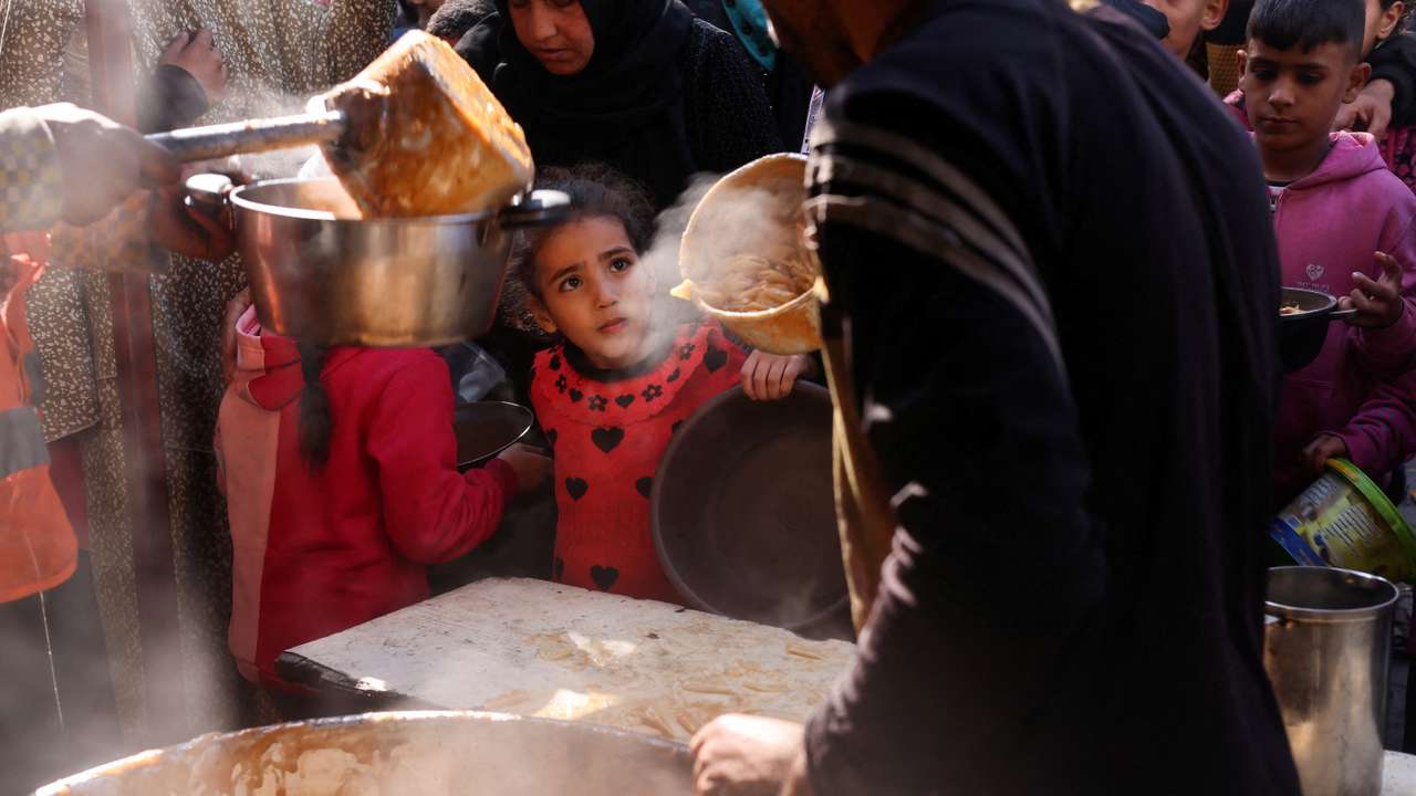 Palestinians wait to receive food amid shortages of food supplies, in Rafah in the southern Gaza Strip