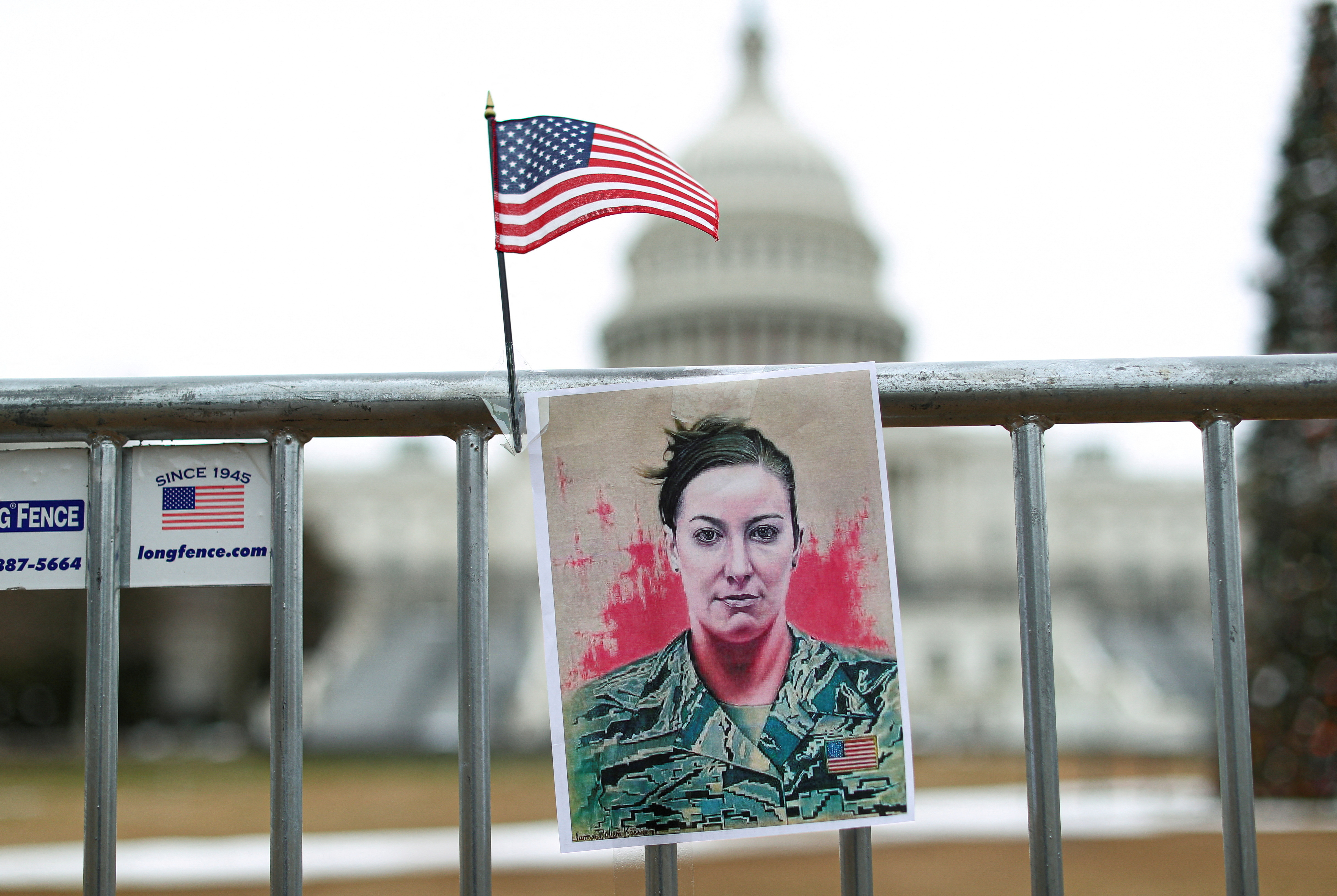 FILE PHOTO: A portrait of Ashli Babbitt hangs on a fence outside the US Capitol