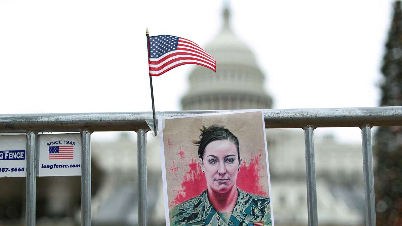 FILE PHOTO: A portrait of Ashli Babbitt hangs on a fence outside the US Capitol