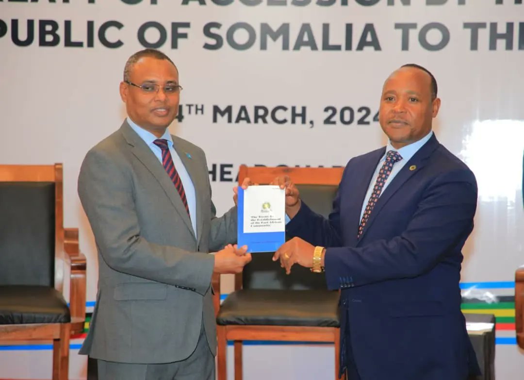 Somalia’s Minister of Commerce and Industry, Jibril Abdirashid Haji Abdi (L), presents the instrument of ratification of the treaty of accession to EAC Secretary-General Peter Mathuki (R) on March 4, 2023, in Arusha, Tanzania.