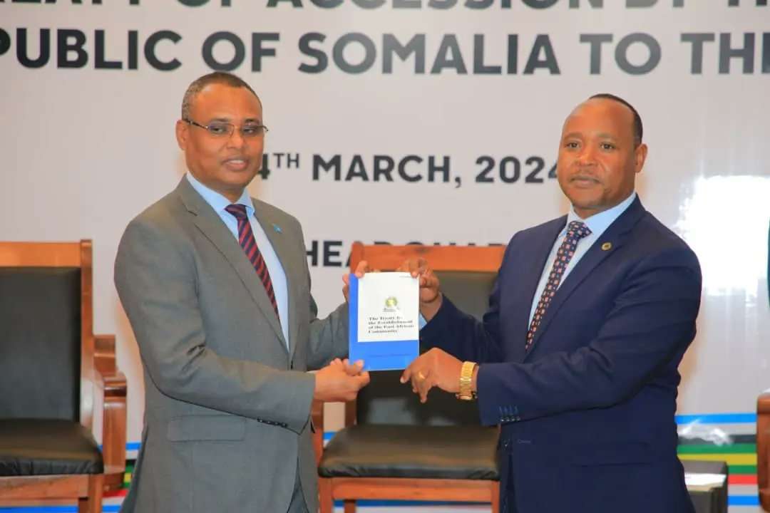 Somalia’s Minister of Commerce and Industry, Jibril Abdirashid Haji Abdi (L), presents the instrument of ratification of the treaty of accession to EAC Secretary-General Peter Mathuki (R) on March 4, 2023, in Arusha, Tanzania.