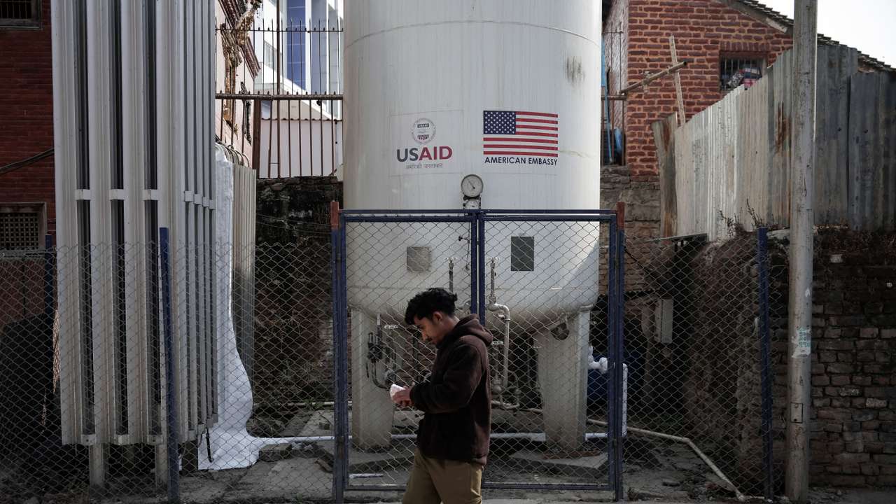 A man walks past the liquid oxygen storage tank installed at Bir Hospital by the United States Agency for International Development (USAID), in Kathmandu