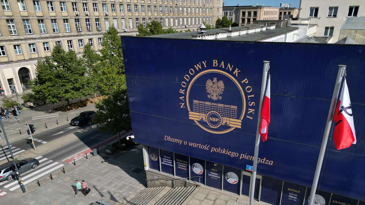 People walk in front of the Polish Central Bank (NBP) in Warsaw