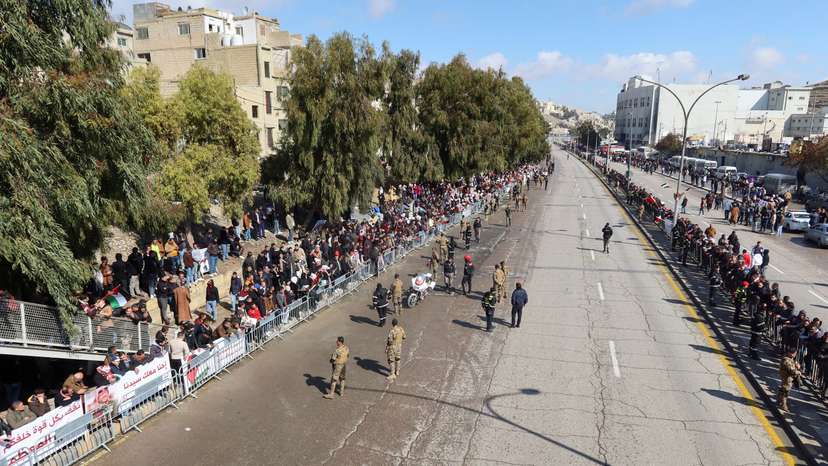 People gather along a road to welcome Jordan's King Abdullah upon his return from the U.S., in Amman