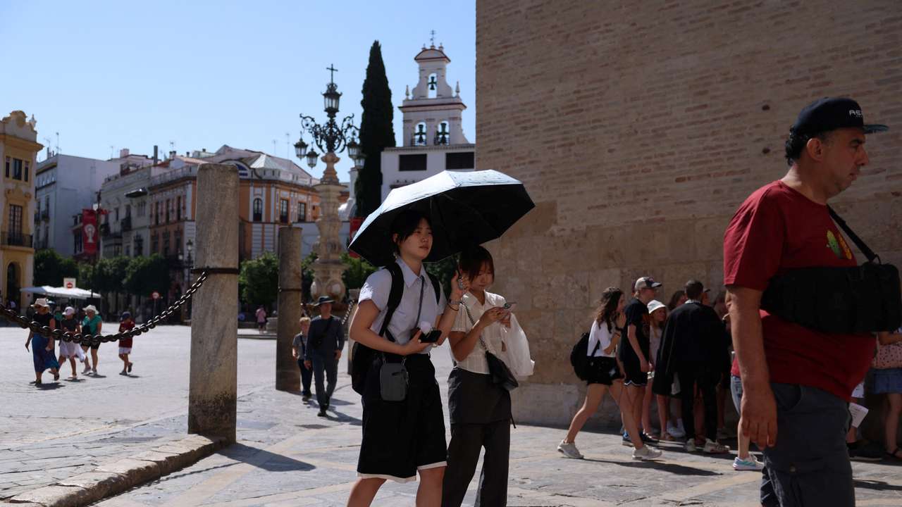 People walk during a heatwave, in Seville
