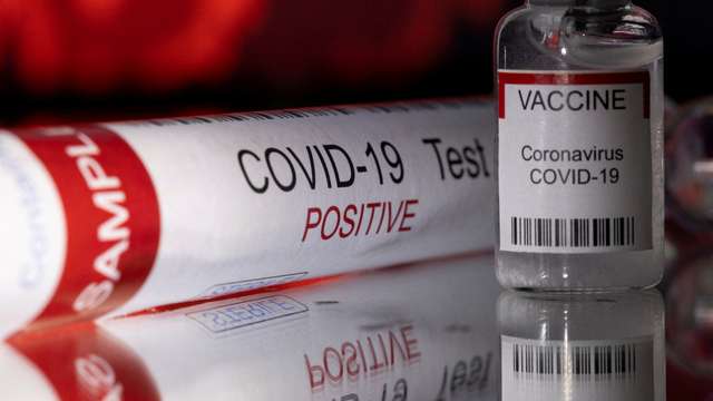 FILE PHOTO: Illustration shows a test tube labelled "COVID-19 Test positive" and a vial labelled "VACCINE Coronavirus COVID-19\