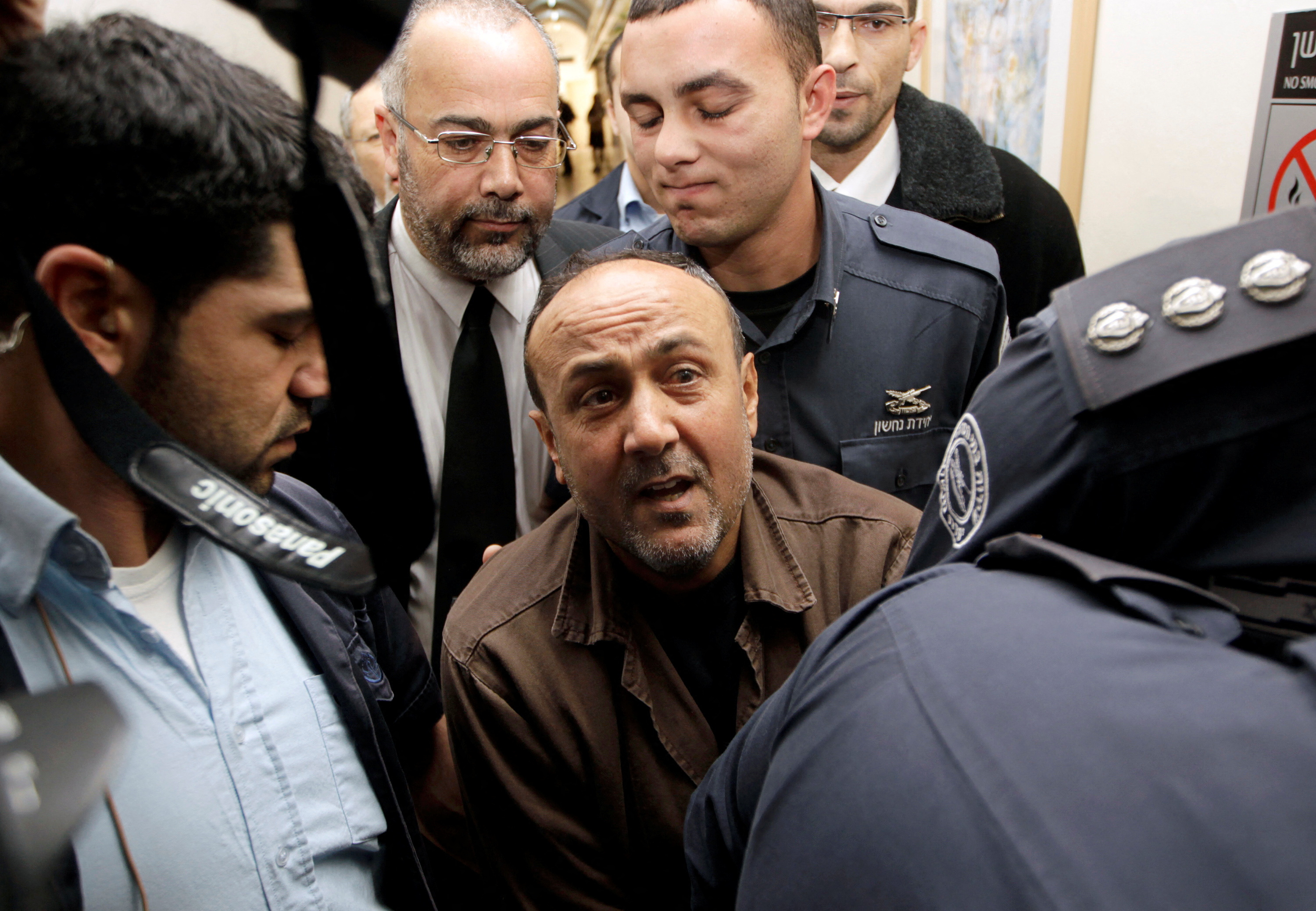 FILE PHOTO: Jailed Fatah leader Barghouti is accompanied by Israeli prison guards in Jerusalem