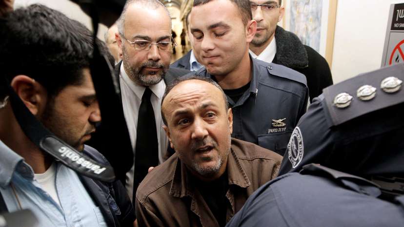 FILE PHOTO: Jailed Fatah leader Barghouti is accompanied by Israeli prison guards in Jerusalem