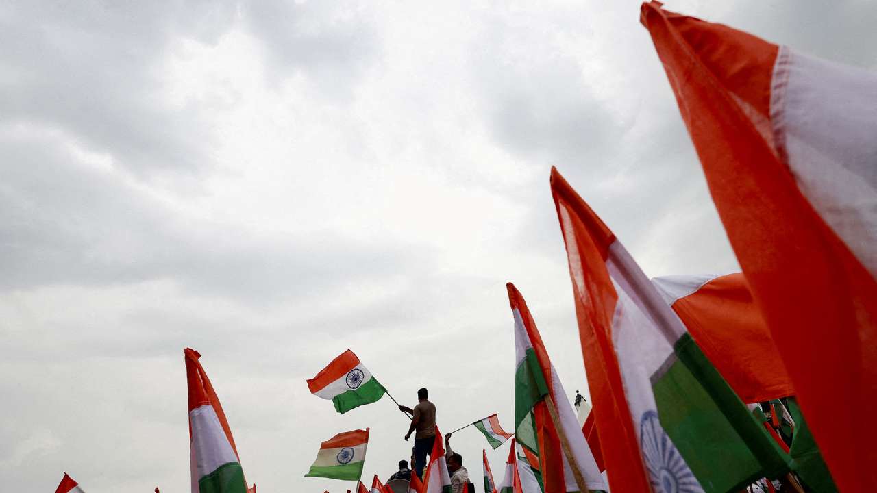 FILE PHOTO: People wave Indian flags in support of the Indian Armed Forces, following the ceasefire announcement between India and Pakistan, in Delhi