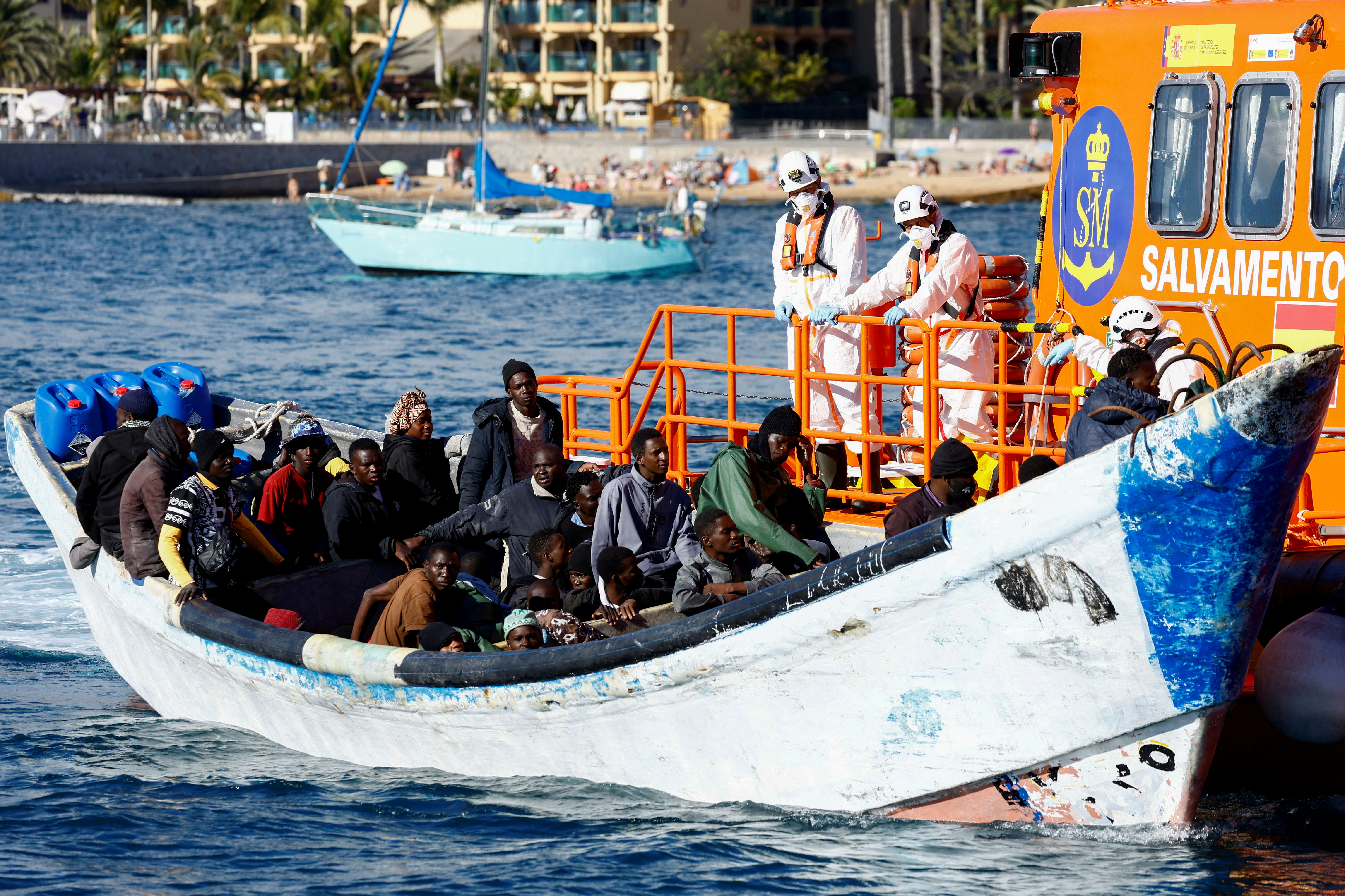 FILE PHOTO: A Spanish Coast Guard vessel tows a fibreglass boat with migrants onboard to the port of Arguineguin, on the island of Gran Canaria