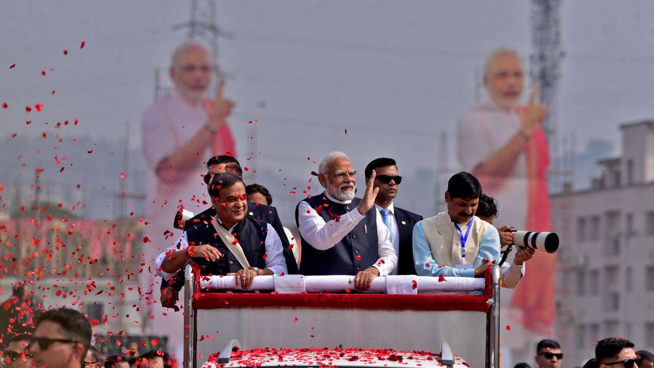 PM Modi waves to his supporters as he arrives to attend a rally in Guwahati