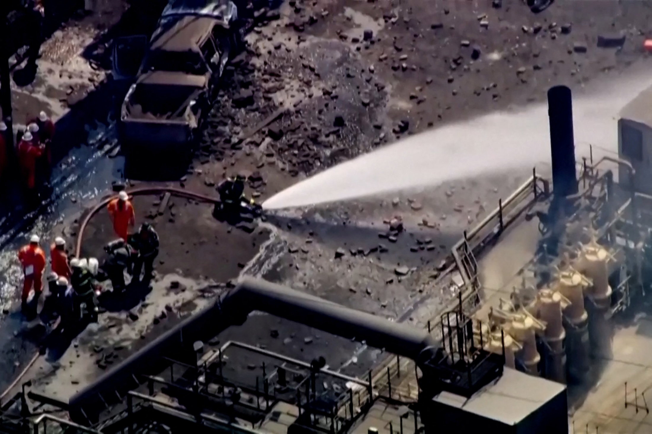 Firefighters spray water on the site of an explosion at U.S. Steel's Clairton Coke Works plant in Clairton