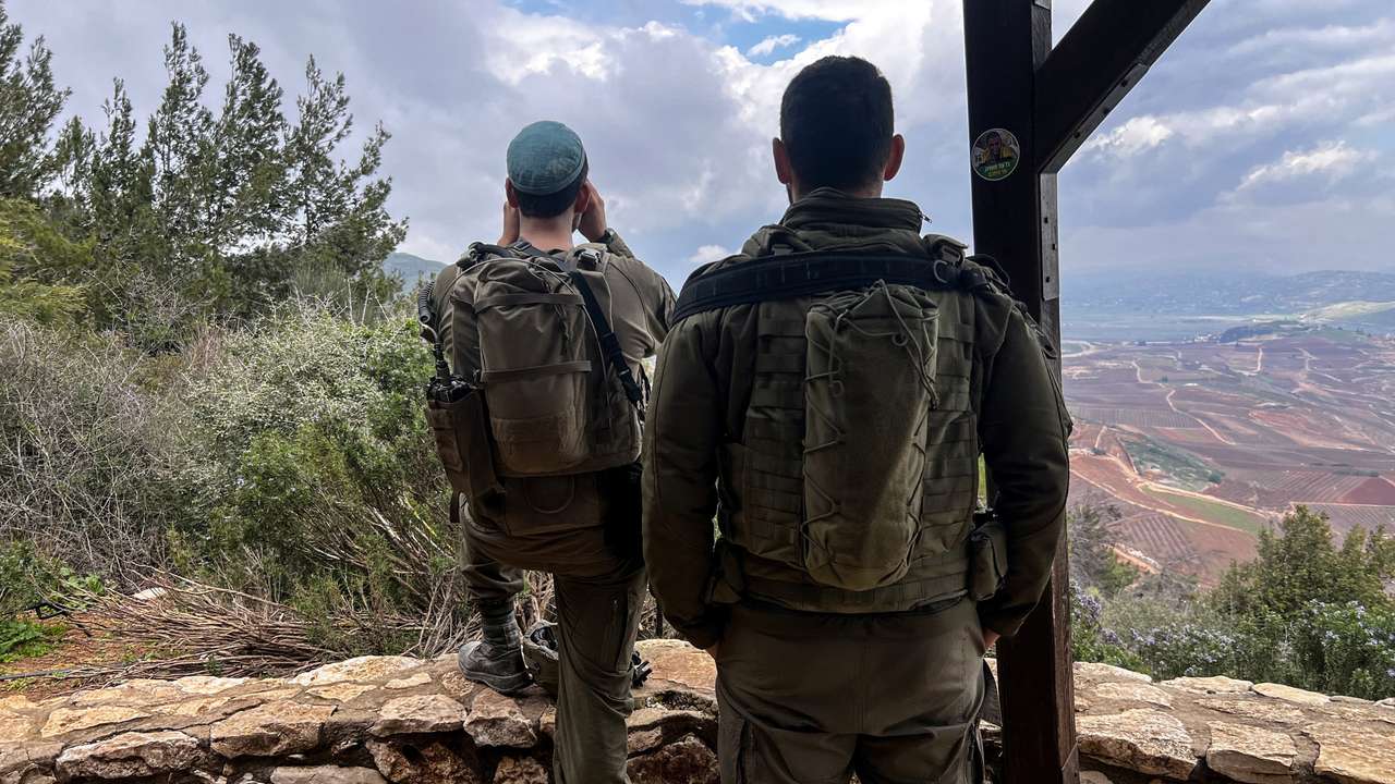 Israeli soldiers look towards Lebanon, amid an escalation between Iran-backed Hezbollah and Israel, by the Israel-Lebanon border