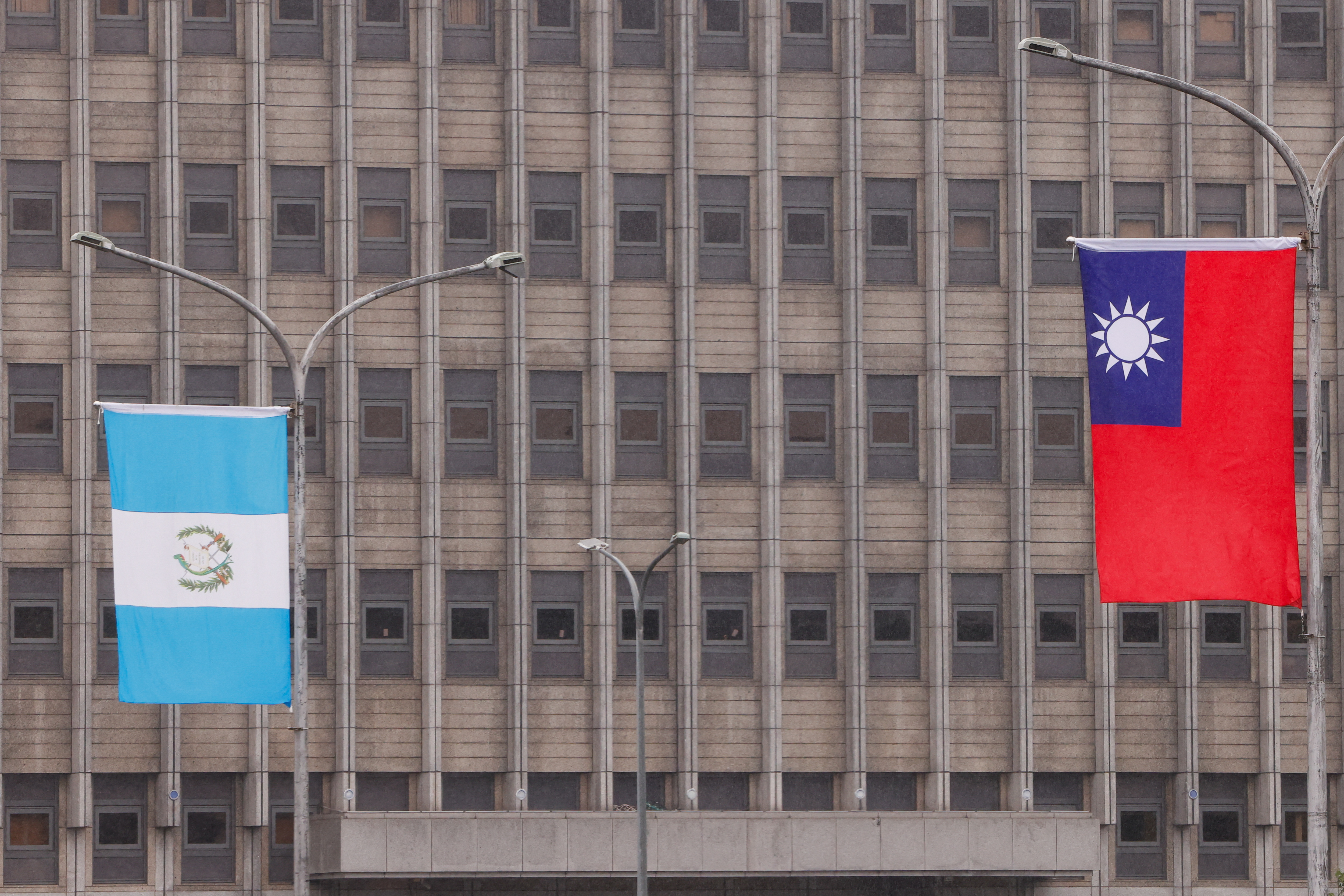 The national flags of Taiwan and Guatemala flutter outside the Presidential Office Building in Taipei