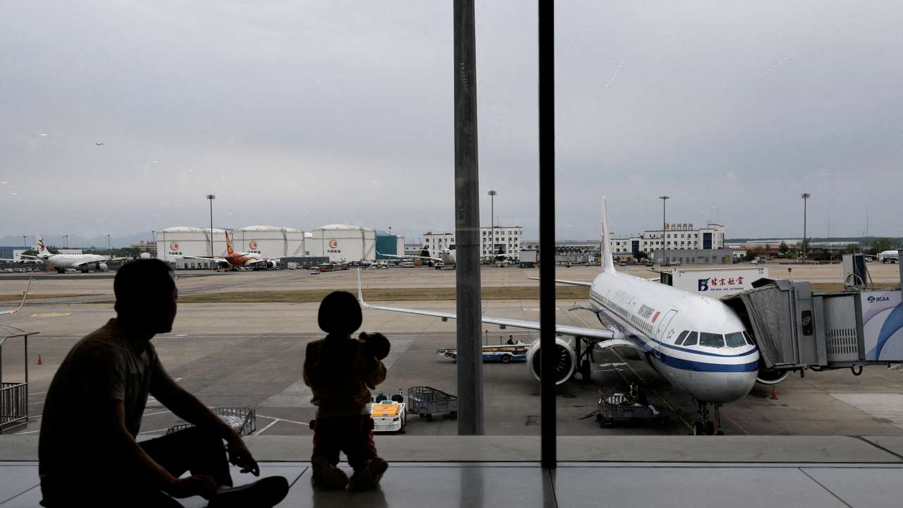 FILE PHOTO: Passengers look at the tarmac as they wait for their flights at the Beijing Capital International Airport, in Beijing