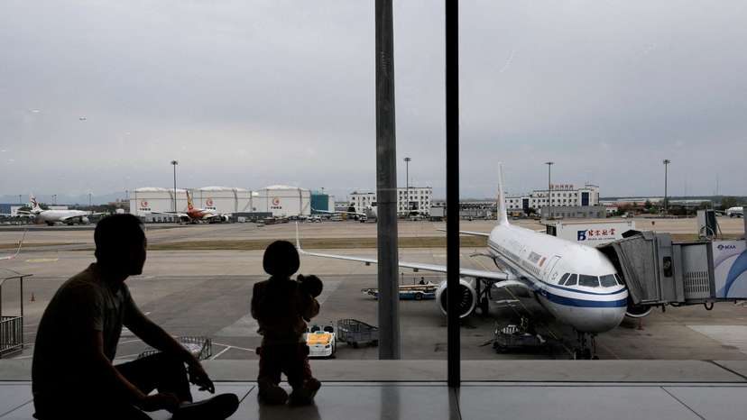 FILE PHOTO: Passengers look at the tarmac as they wait for their flights at the Beijing Capital International Airport, in Beijing