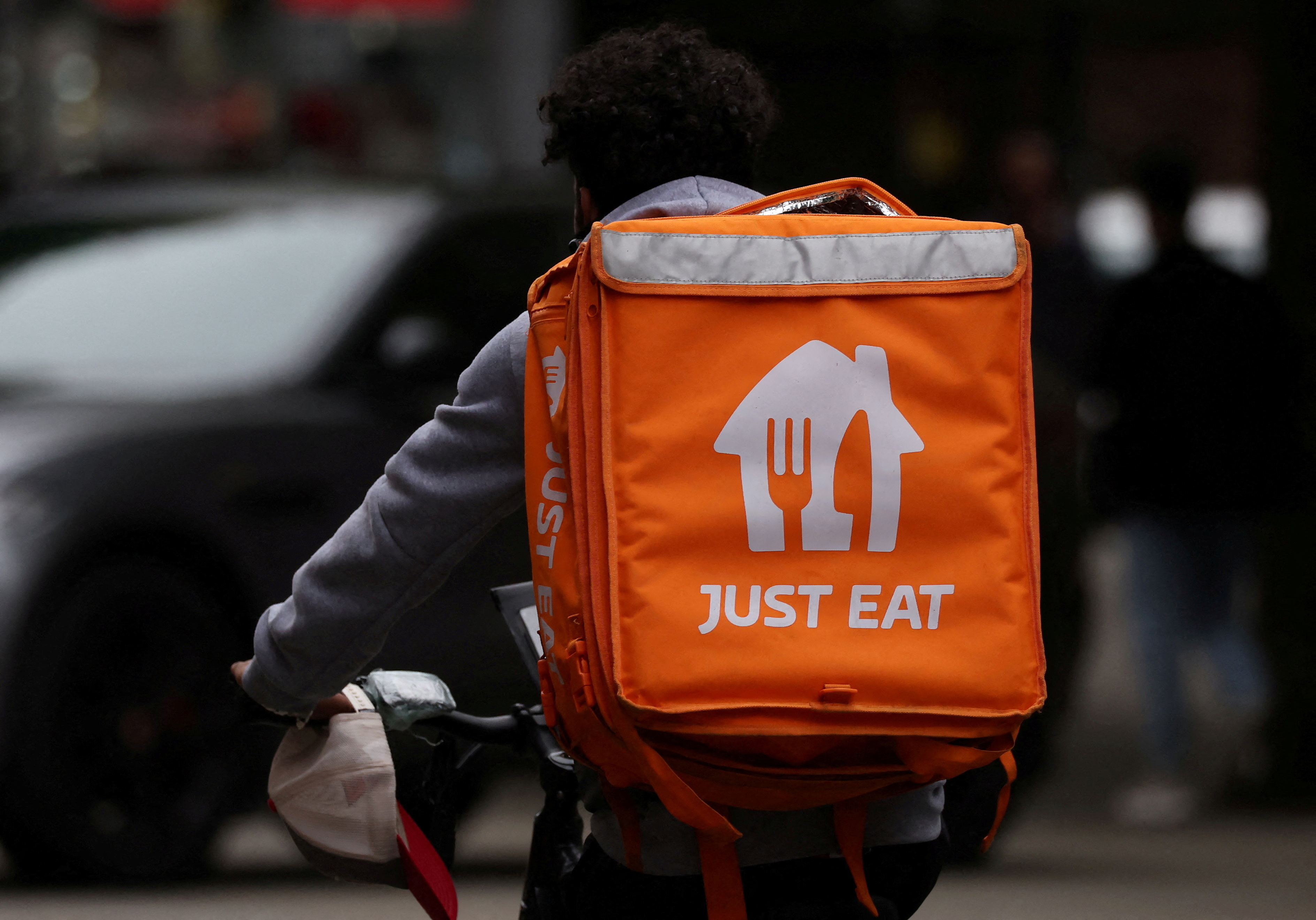 FILE PHOTO: A Just Eat delivery rider cycles through Manchester