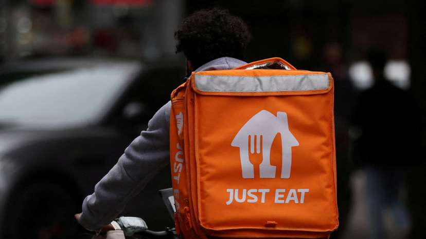FILE PHOTO: A Just Eat delivery rider cycles through Manchester