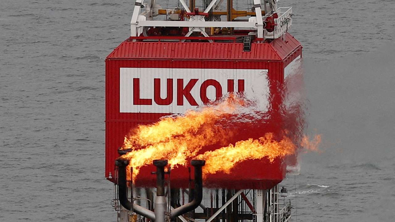 FILE PHOTO: A gas torch is seen next to the Lukoil company sign at the Filanovskogo oil platform in the Caspian Sea
