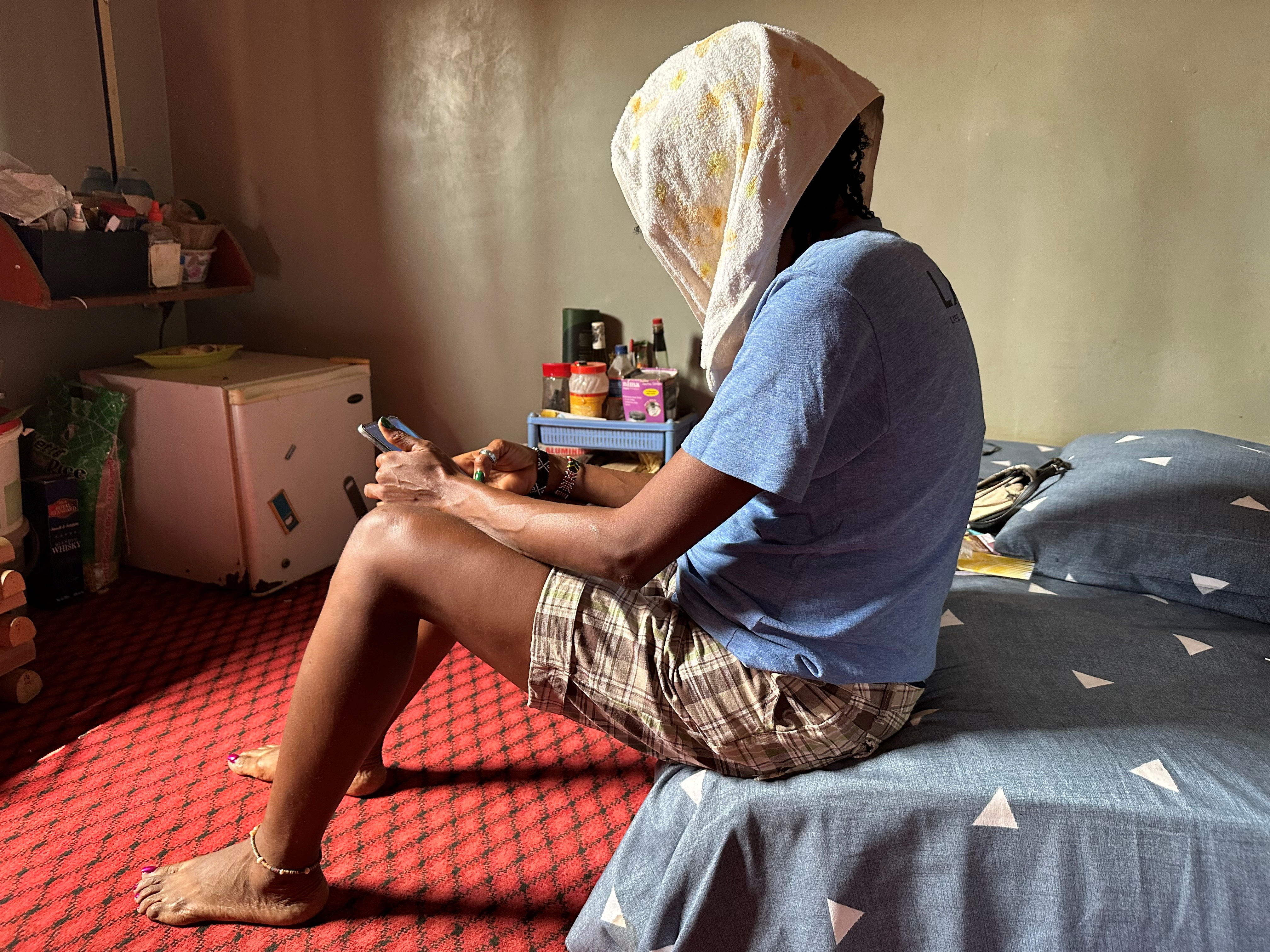Jane, 39, a Nigerian lesbian, sits on her bed in her apartment in Makurdi
