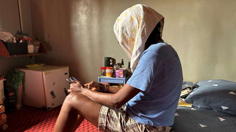 Jane, 39, a Nigerian lesbian, sits on her bed in her apartment in Makurdi