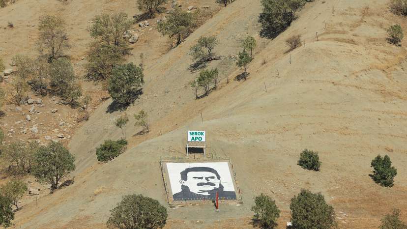 A portrait of jailed Kurdistan Workers Party leader Abdullah Ocalan and a sign with the words "Serok Apo," are displayed on a hillside in the Qandil mountains