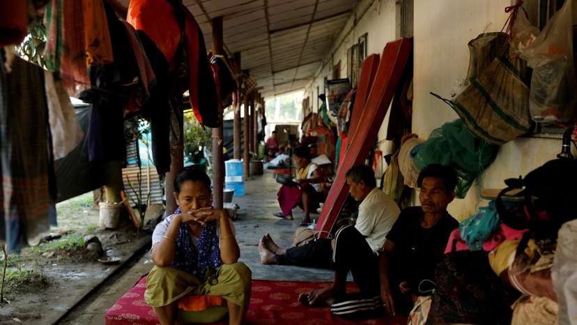 FILE PHOTO: People sit inside a relief camp for displaced Meiteis after their homes and shops were set ablaze, in Borobekra