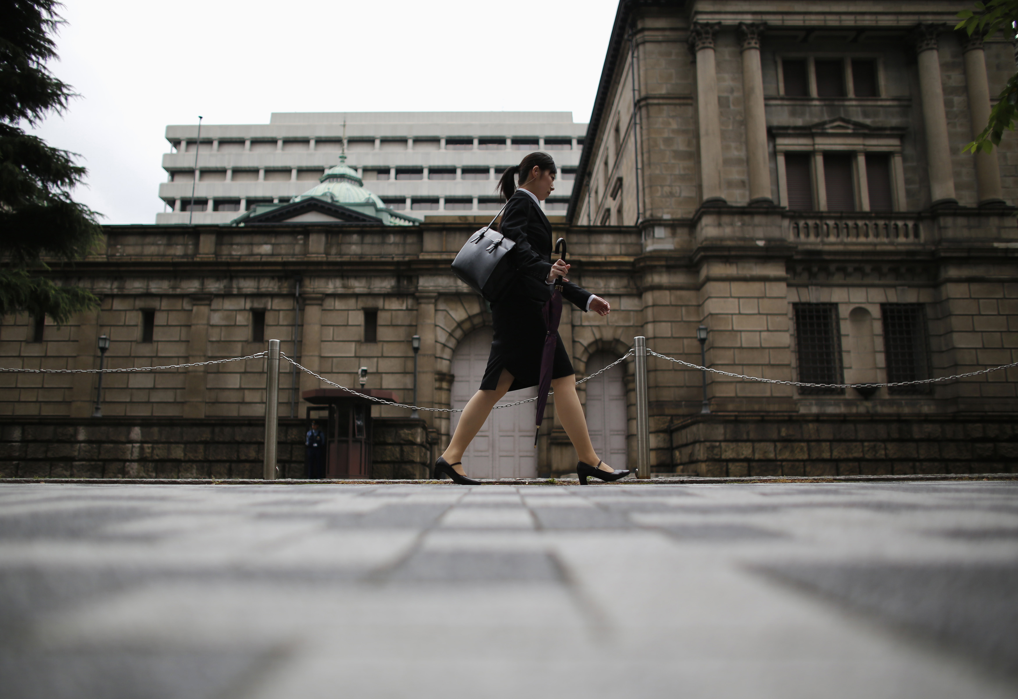 Woman walks past the Bank of Japan headquarters in Tokyo