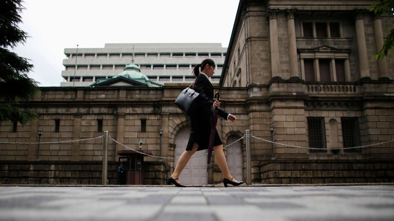 Woman walks past the Bank of Japan headquarters in Tokyo