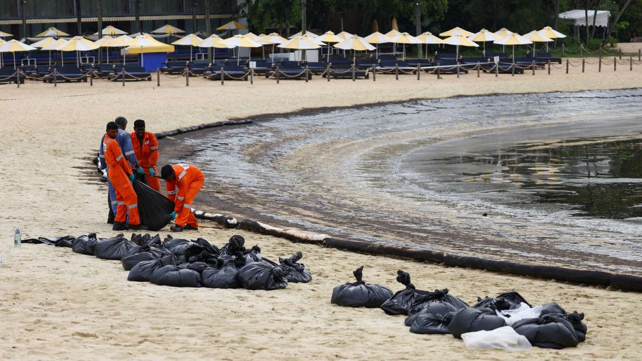 Workers clean up the oil slick at Tanjong Beach in Sentosa