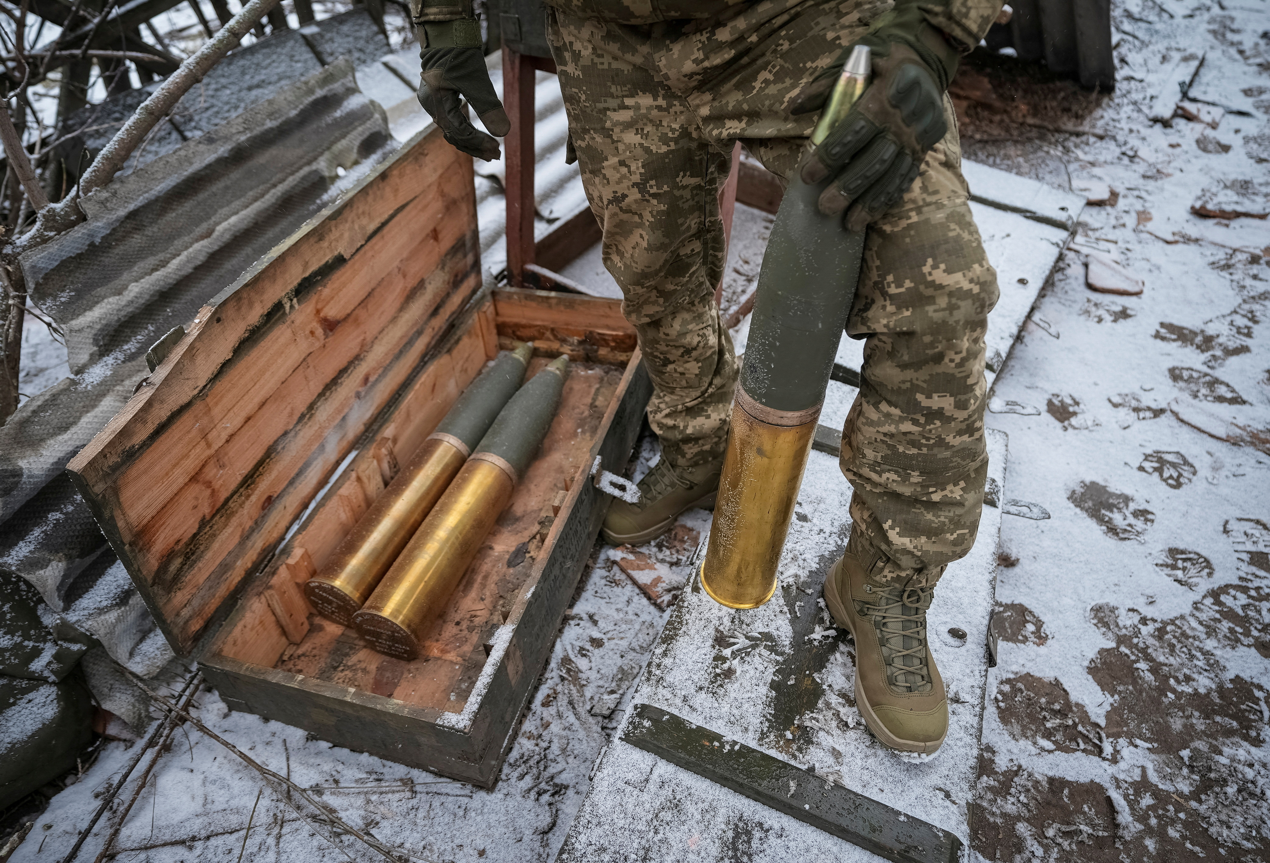 FILE PHOTO: Ukrainian serviceman prepares shells to fire a L119 howitzer towards Russian at a position near Bakhmut