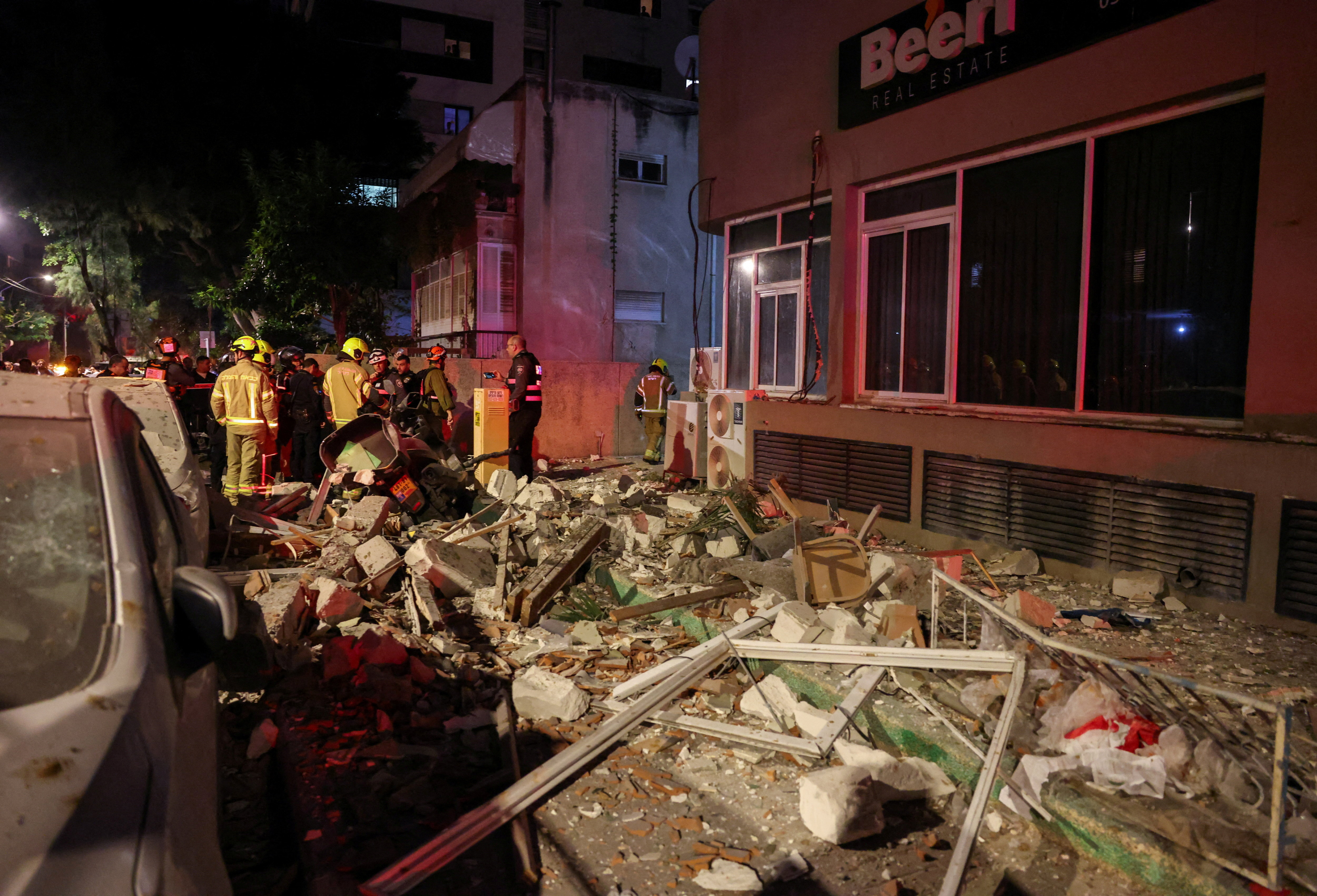 Emergency personnel inspect damage in a building following an Iranian projectile strike, amid the U.S.-Israeli conflict with Iran, in Ramat Gan