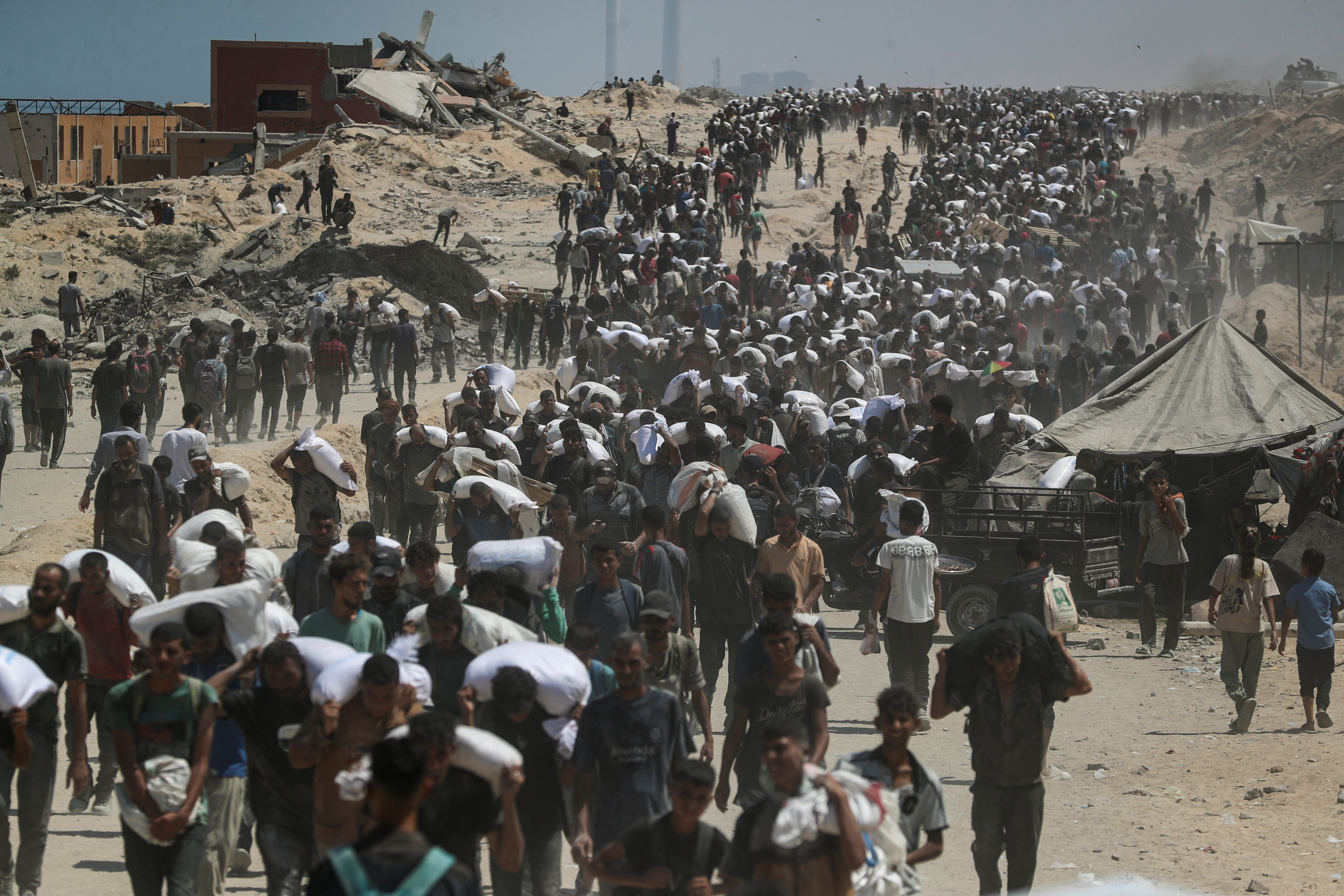 Palestinians carry aid supplies that entered Gaza through Israel, in Beit Lahia