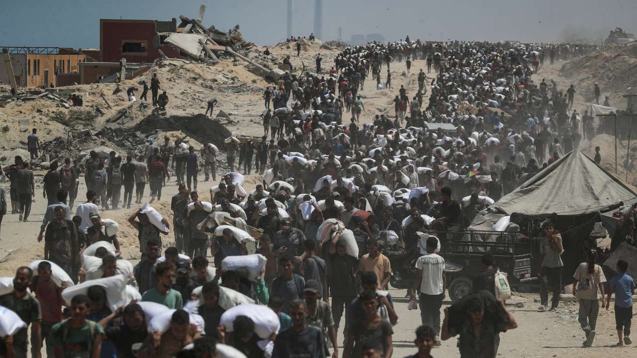 Palestinians carry aid supplies that entered Gaza through Israel, in Beit Lahia