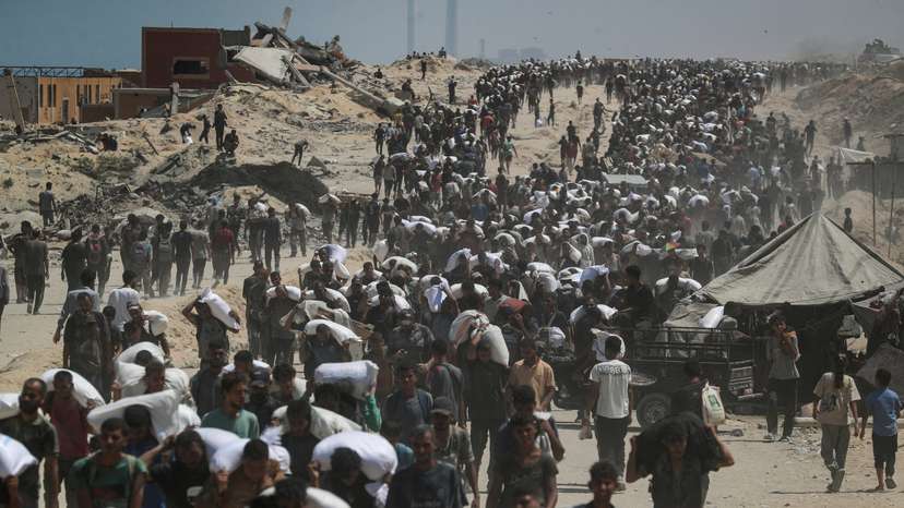 Palestinians carry aid supplies that entered Gaza through Israel, in Beit Lahia